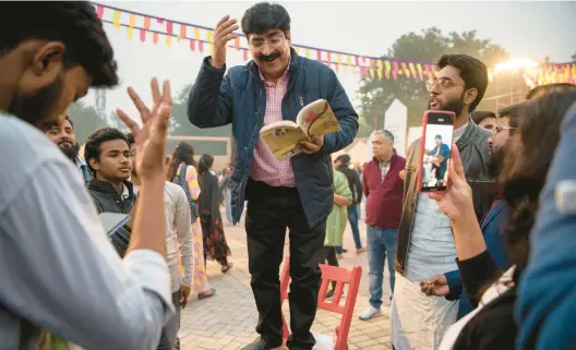  ?? SAUMYA KHANDELWAL/THE NEW YORK TIMES 2022 ?? Poet and lyricist Pradeep Sahil draws a crowd in New Delhi with a recitation during the Urdu poetry festival Jashn-e-rekhta.