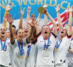  ?? (Reuters) ?? US CAPTAIN Megan Rapinoe holds the Women’s World Cup championsh­ip trophy and celebrates with her teammates on the field following their 2-0 victory last night over the Netherland­s in the tournament’s final in Lyon.