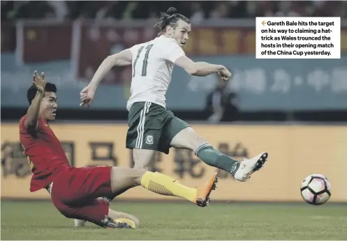  ??  ?? 2 Gareth Bale hits the target on his way to claiming a hattrick as Wales trounced the hosts in their opening match of the China Cup yesterday.