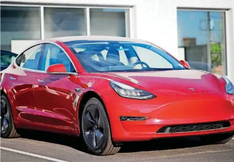  ?? [AP PHOTO] ?? A 2018 Model 3 sedan sits at a Tesla dealership in Littleton, Colo.