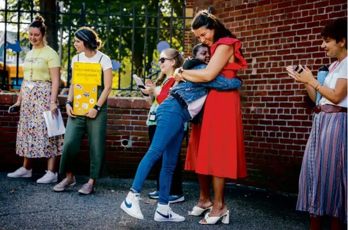  ?? ERIN CLARK/GLOBE STAFF ?? Lexy Marsh, a social worker at the Holmes Innovation School in Dorchester, hugged students as they arrived Thursday for the first day of school.