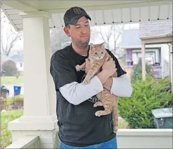  ?? [BROOKE LAVALLEY/DISPATCH] ?? Eddie Kinnaman bought his home in part for the porch and backyard, so that Billie and his three other cats would have plenty of space to explore outside.