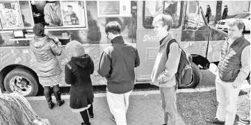  ??  ?? Lunchtime finds Schonander, a sophomore at George Washington University double-majoring in internatio­nal affairs and economics, queing up at a food truck.