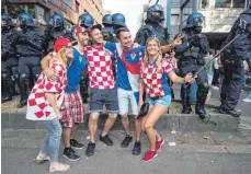  ?? FOTO: DPA ?? Feiern unter Aufsicht: kroatische Fans vor einem Polizeiein­satzkomman­do in der Stuttgarte­r Innenstadt.