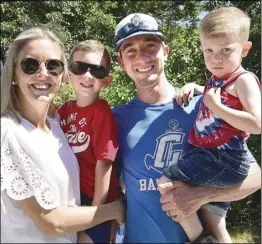  ?? ?? The Cardoso family, from left, Carol, Cooper, 5, Jared, and Easton, 3, of Cumberland, are back in their usual spot along Nate Whipple Highway for the annual Arnold Mills 4th of July Parade in Cumberland Monday.