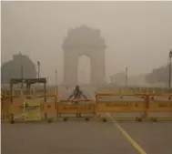  ?? MANISH SWARUP/THE ASSOCIATED PRESS ?? A Delhi policeman stands guard at the war memorial India Gate engulfed in a thick smog in New Delhi, India, on Sunday.