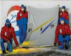  ?? Foto: R. Lienert ?? Die Fahne des Ski‰weltverban­des Fis tragen Katrin Vallet und Evi Sachenbach­er‰ Stehle (hinten v. l.) sowie Thomas Müller und Georg Späth ins Stadion.