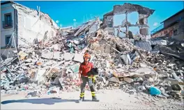  ??  ?? A fireman stands next to ruins in the central street of Amatrice in central Italy, which was ravaged in a strong earthquake that claimed at least 247 lives.