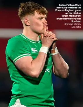  ?? ?? Ireland’s Bryn Ward nervously watches the France v England game on the pitch at Virgin Media Park after their victory over Scotland