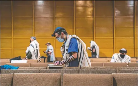  ??  ?? Gavriel Levy of Oakland prays during the daily morning prayer service at Shaare Torah.