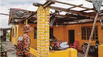  ?? BERNAMA PIX ?? A fireman inspecting one of the homes damaged by the severe storm in Sekinchan, Selangor, yesterday.
