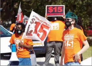  ?? (AP/John Raoux) ?? Cristian Cardona (right), an employee at a McDonald’s, attends a rally for a $15 an hour minimum wage earlier this month in Orlando, Fla.