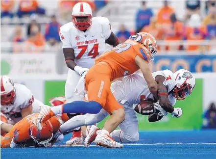  ?? OTTO KITSINGER/ASSOCIATED PRESS ?? Boisie State linebacker Leighton Vander Esch, center, causes a fumble by New Mexico running back Richard McQuarley (3) in the first half of their MWC game Thursday night.