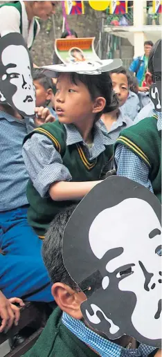 ?? Picture Ashwini Bhatia ?? Exiled Tibetan children in Dharmsala, India wear masks of Gedhun Choekyi Nyima, the Panchen Lama, who, aged six, was taken by Chinese security forces