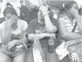  ??  ?? Three women weep while waiting for informatio­n outside the shelter La Gran Familia (The Big Family) where a police raid on Tuesday rescued 596 people, including 458 children in Zamora, Michoacan State, Mexico