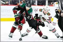  ?? ?? Arizona Coyotes center Jack McBain (22) keeps the puck away from Chicago Blackhawks center Dylan Strome (17) during the second period of an NHL hockey game in Glendale, Ariz. The Blackhawks won 4-3 in overtime. (AP)