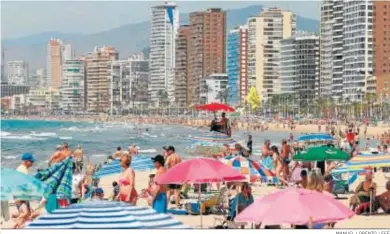  ?? MANUEL LORENZO / EFE ?? La playa de Benidorm estaba ayer atestada de bañistas.