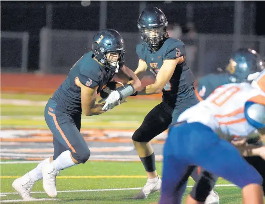  ?? STEVE JOHNSTON/DAILY SOUTHTOWN ?? Lincoln-Way West quarterbac­k Cole Crafton hands the ball to Jason Harris during Friday’s game against Stagg in New Lenox.