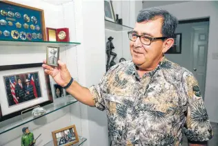  ?? Tom Reel / Staff photograph­er ?? Pete Flores shows an early game warden photo of himself as he talks about his plans while at his home in Pleasanton.