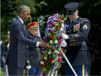  ?? — AP ?? President Barack Obama, with the aid of Sgt. 1st Class John C. Wirth, lays a wreath at the Tomb of the Unknowns on Monday, Memorial Day, at Arlington National Cemetery in Arlington, Virginia.