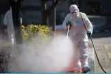  ??  ?? SEOUL: A worker wearing protective gear sprays disinfecta­nt on the street to help prevent the spread of the COVID-19 coronaviru­s, near a hospital yesterday. —AFP