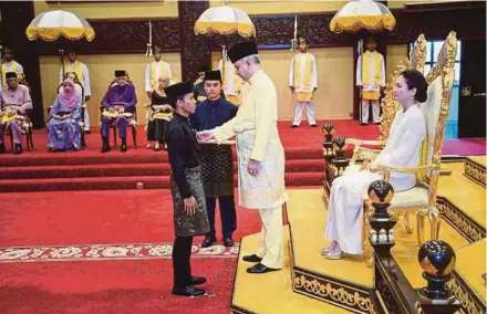  ?? BERNAMA PIC ?? Sultan of Perak Sultan Nazrin Muizzuddin Shah conferring the Pingat Jasa Kebaktian on Perak footballer Ahmad Khairil Anuar Ahmad Zamri at the investitur­e at Istana Iskandaria­h in Kuala Kangsar yesterday.