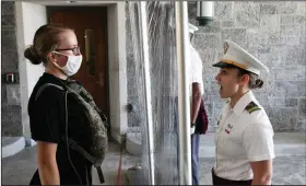  ?? (AP/Mark Lennihan) ?? A new cadet (left) listens as First Class Cadet Madison Teague yells commands from the other side of a plastic screen Monday at the U.S. Military Academy in West Point, N.Y.