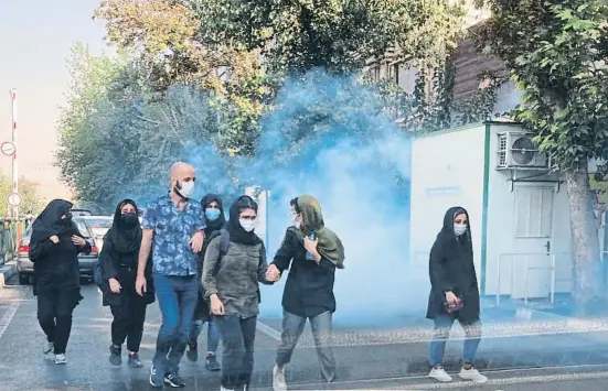 ?? AP ?? Manifestan­ts apartant-se del gas lacrimogen llançat per la policia dissabte davant la Universita­t de Teheran