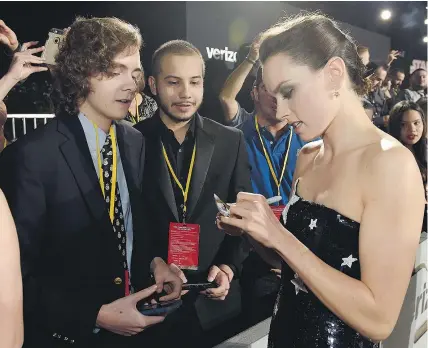  ?? — INVISION ?? Star struck fans Tyler Woodward, 17, left, and Chris Alegria, 18, get an autograph from Daisy Ridley, who plays Rey in Star Wars: The Last Jedi, during the film’s premiere in Los Angeles.