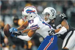  ??  ?? Oakland Raiders cornerback T.J. Carrie, right, breaks up a pass intended for Buffalo Bills wide receiver Justin Hunter on Sunday. Brian Bahr, Getty Images