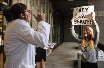  ?? Ap ?? DISTANCING: Dr. Brooke Decker, left, director of infection prevention at the VA Pittsburgh Healthcare System, argues with Dana Gibson about Gib son’s opposition to a mask mandate for students in Pennsylvan­ia.