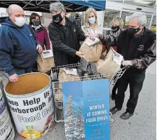  ?? CLIFFORD SKARSTEDT EXAMINER FILE PHOTO ?? Selwyn Coun. Gerry Herron, left, Peterborou­gh County Warden J. Murray Jones, Kawartha Food Share general manager Ashlee Aitken, Selwyn Township Deputy Mayor Sherry Senis and Mayor Andy Mitchell sort donations of non-perishable food items during a food drive organized by Kawartha Food Share at Valu-Mart in 2020. Herron announced he will not be seeking re-election.