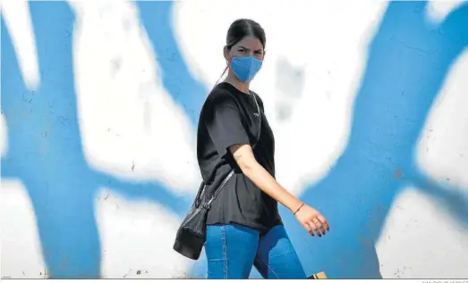  ?? JUAN CARLOS VÁZQUEZ ?? Una mujer pasea por la calle con una mascarilla puesta.