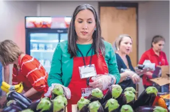  ?? ROBERTO E. ROSALES/JOURNAL ?? Community Health Manager Tatiana Falcon Rodriguez sets out eggplants delivered by Roadrunner Food Bank to the Food Pharmacy on Presbyteri­an Kaseman Hospital’s campus.