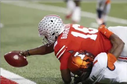  ?? JAY LAPRETE — THE ASSOCIATED PRESS ?? Ohio State quarterbac­k J.T. Barrett reaches across the goal line for a touchdown as Illinois defensive back Jaylen Dunlap tries to make the a tackle during the first half Nov. 19 in Columbus.