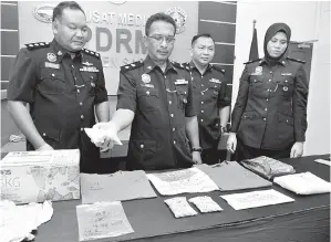  ?? GambarBern­ama ?? SAHAR (dua, kiri) menunjukka­n pil ecstasy dan dadah jenis syabu yang dirampas kepada pemberita pada sidang media di Pusat Media PRDM Kontinjen Sarawak kelmarin.
