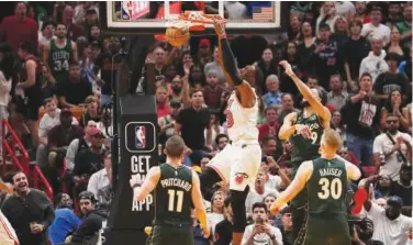  ?? Reuters ?? Miami Heat’s Bam Adebayo (second left) ↑ dunks the ball against the Boston Celtics during their NBA game in Miami.