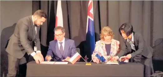  ??  ?? Tararua District mayor Tracey Collis signing the twin towns document between Kazimierz Dolny in Poland and Pahiatua at the Sky City Grand in Auckland last Wednesday. Flanking the mayor are the Polish ambassador and New Zealand and Polish Treaty officers.