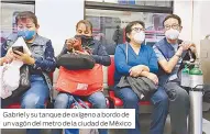  ??  ?? Gabriel y su tanque de oxígeno a bordo de un vagón del metro de la ciudad de México
