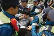  ?? CHUNG SUNG-JUN / GETTY IMAGES ?? South Korean policemen drag out an activist who opposes releasing balloons containing leaflets denouncing North Korean leader Kim Jong-Un during a rally on Saturday in Paju, South Korea.