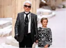  ??  ?? In this file photo taken on May 3, 2017 German fashion designer Karl Lagerfeld acknowledg­es the audience with his godson Hudson Kroenig at the end of his Chanel Croisiere (Cruise) fashion show at the Grand Palais in Paris.