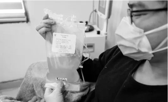  ?? AP ?? Dr Zhou Min, a recovered COVID-19 patient who has passed his 14-day quarantine, donates plasma in the city’s blood centre in Wuhan in central China’s Hubei province.