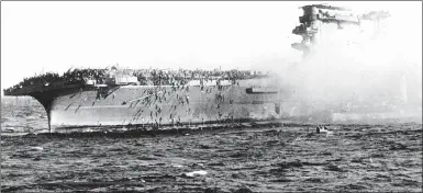  ?? Associated Press photo ?? In this 1942 file photo, crew abandons the USS Lexington after the decks of the aircraft carrier sunk in the Battle of the Coral Sea.