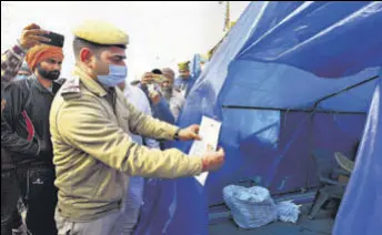  ?? RAJ K RAJ/HT ?? A policeman puts up a notice outside the tent of Rakesh Tikait and Jagtar Singh Bajwa at Ghazipur border on Thursday.