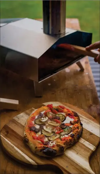  ?? PHOTOS BY GETTY IMAGES ?? A portable pizza oven, which cooks tasty pies in two minutes flat, makes a backyard pizza party easy.