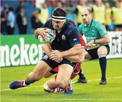  ?? PHOTO: GETTY IMAGES ?? Romping home . . . Scotland’s Stuart McInally scores his team’s ninth try during the group A game against Russia at Shizuoka Stadium in Fukuroi City yesterday. Scotland trounced Russia 610.