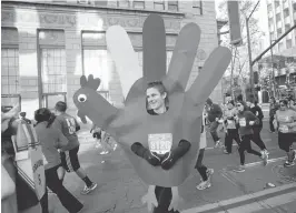  ?? JIM GENSHEIMER/STAFF PHOTOS ?? Matt Giusti, of San Jose, dressed as a giant hand-shaped turkey for the race. His costume took more than 35 hours to make. Matt was an ear of corn for last year’s race.