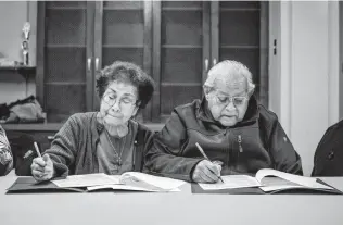  ?? Matthew Busch / Contributo­r ?? Participan­ts Lucy and Robert Sanchez answer health questions as part of the paperwork for the Building a Healthy Temple program.