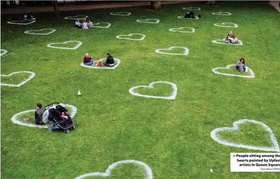  ?? Tom Wren/SWNS ?? People sitting among the hearts painted by Upfest
artists in Queen Square