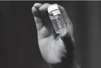  ?? Associated Press ?? A reporter holds up an example of the amount of fentanyl that can be deadly after a news conference about deaths from fentanyl exposure at DEA Headquarte­rs in Arlington, Va.